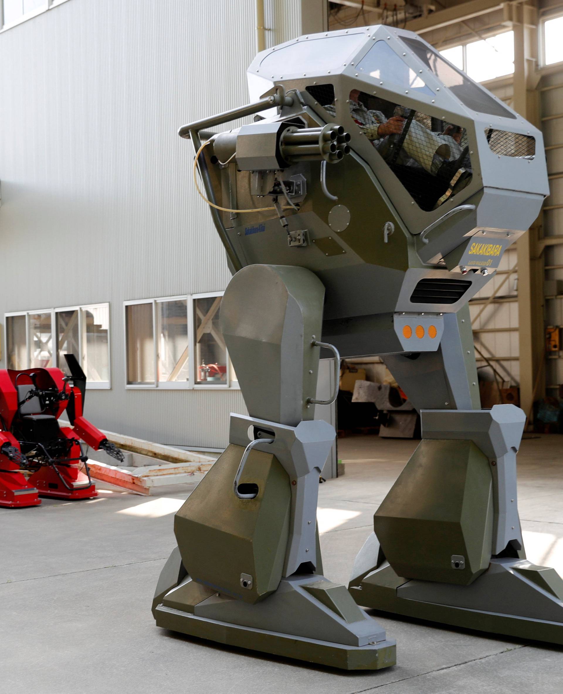 Sakakibara Kikai's engineer Masaaki Nagumo controls the bipedal robot Land Walker during its demonstration at its factory in Shinto Village