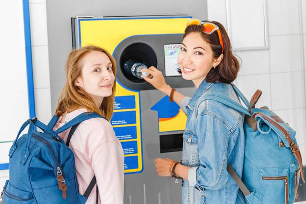 Woman,Friends,Together,At,The,Reverse,Vending,Machine,Recycle,Plastic