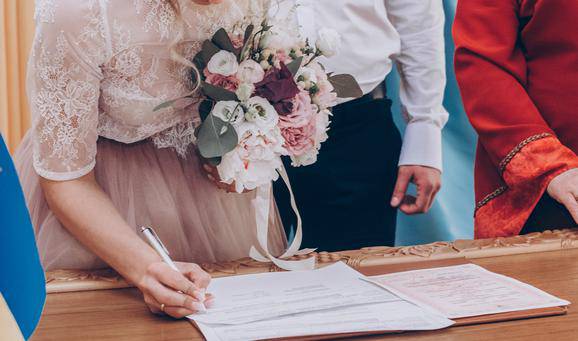 stylish wedding bride and groom signing wedding register. modern
