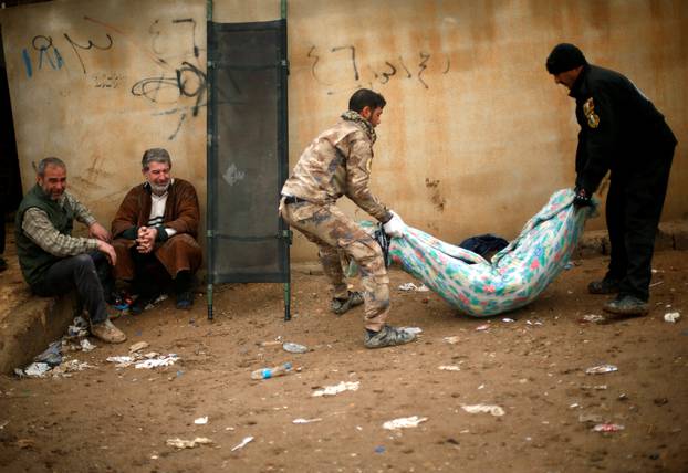 An Iraqi father mourns as soldiers carry the body of his son, who was killed during clashes in the Islamic State stronghold of Mosul, in al-Samah neighborhood, Iraq