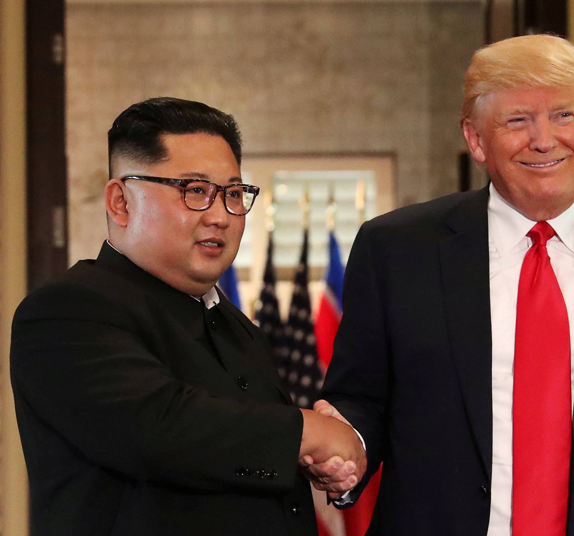 FILE PHOTO: President Donald Trump and North Korea's leader Kim Jong Un shake hands after signing documents during a summit in Singapore