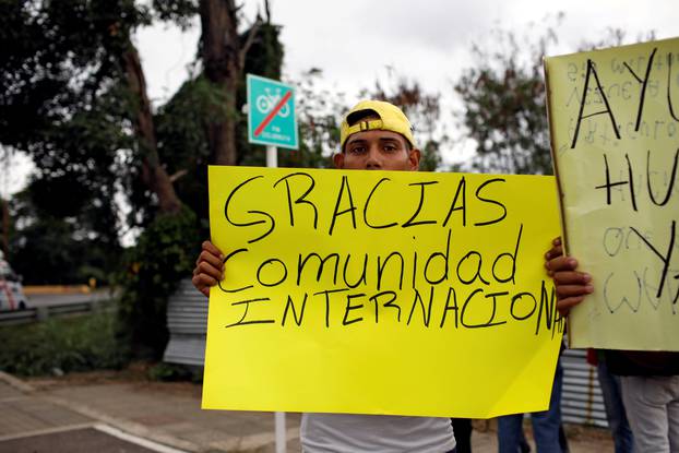 FILE PHOTO: A man holds a banner that reads "Thank you international community" near a warehouse where humanitarian aid for Venezuela is being stored