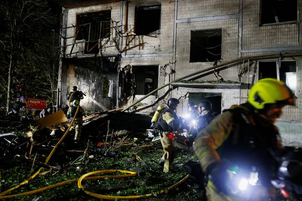 Firefighters work at the site of an apartment building hit by a Russian missile strike in Kyiv