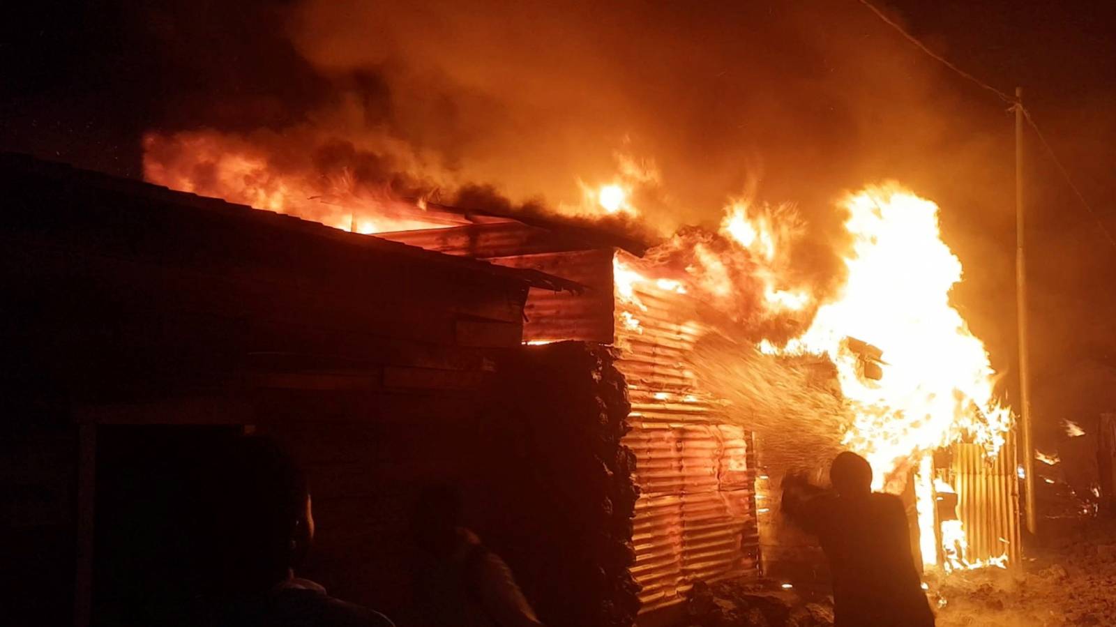 A person attempts to extinguish fire on a building after the volcanic eruption of Mount Nyiragongo, in Goma