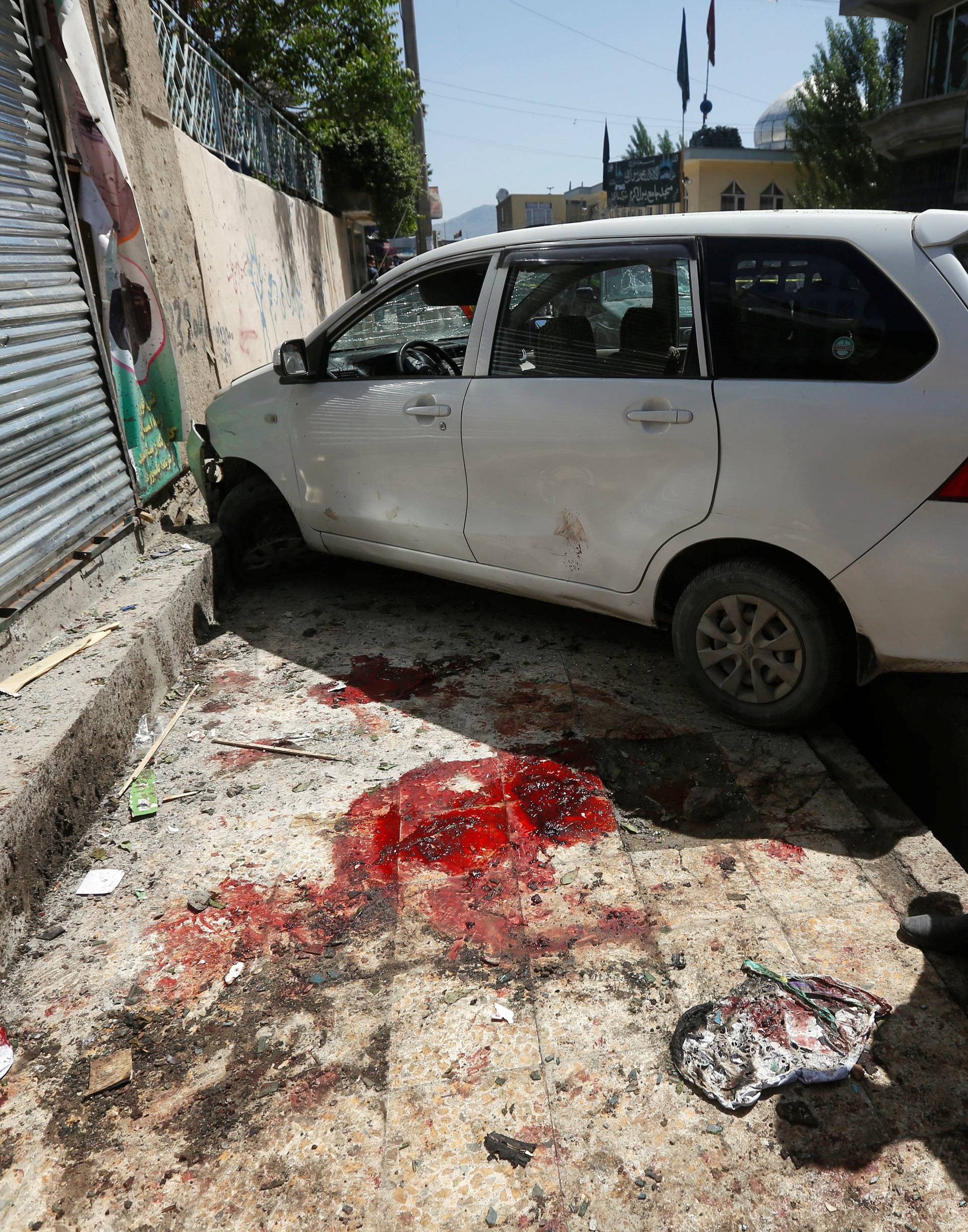 An Afghan man inspects the site of a suicide bomb blast in Kabul, Afghanistan