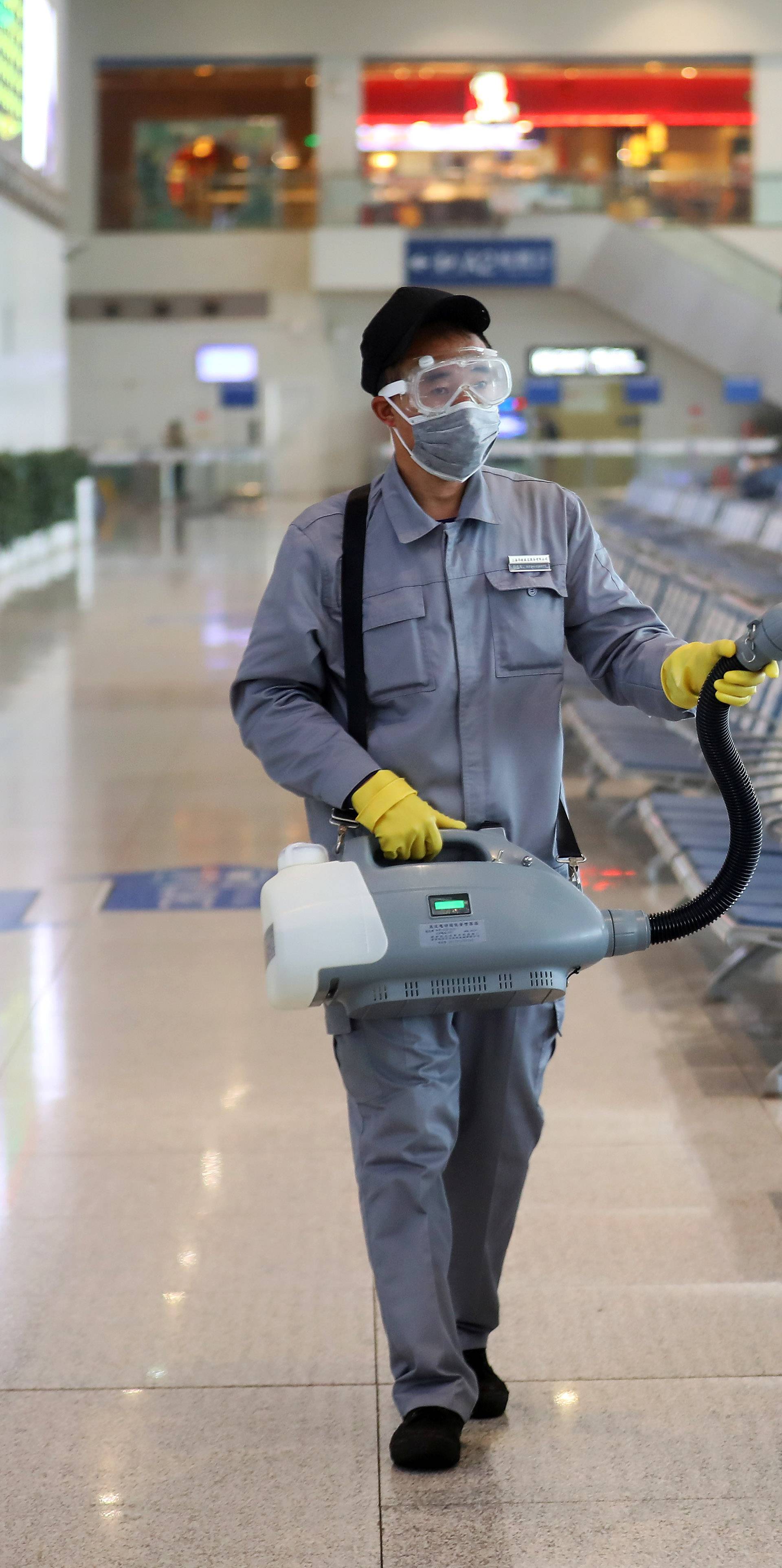 Workers in protective mask disinfects a waiting hall following the outbreak of a new coronavirus at the Nanjing Railway Station, in Nanjing, Jiangsu