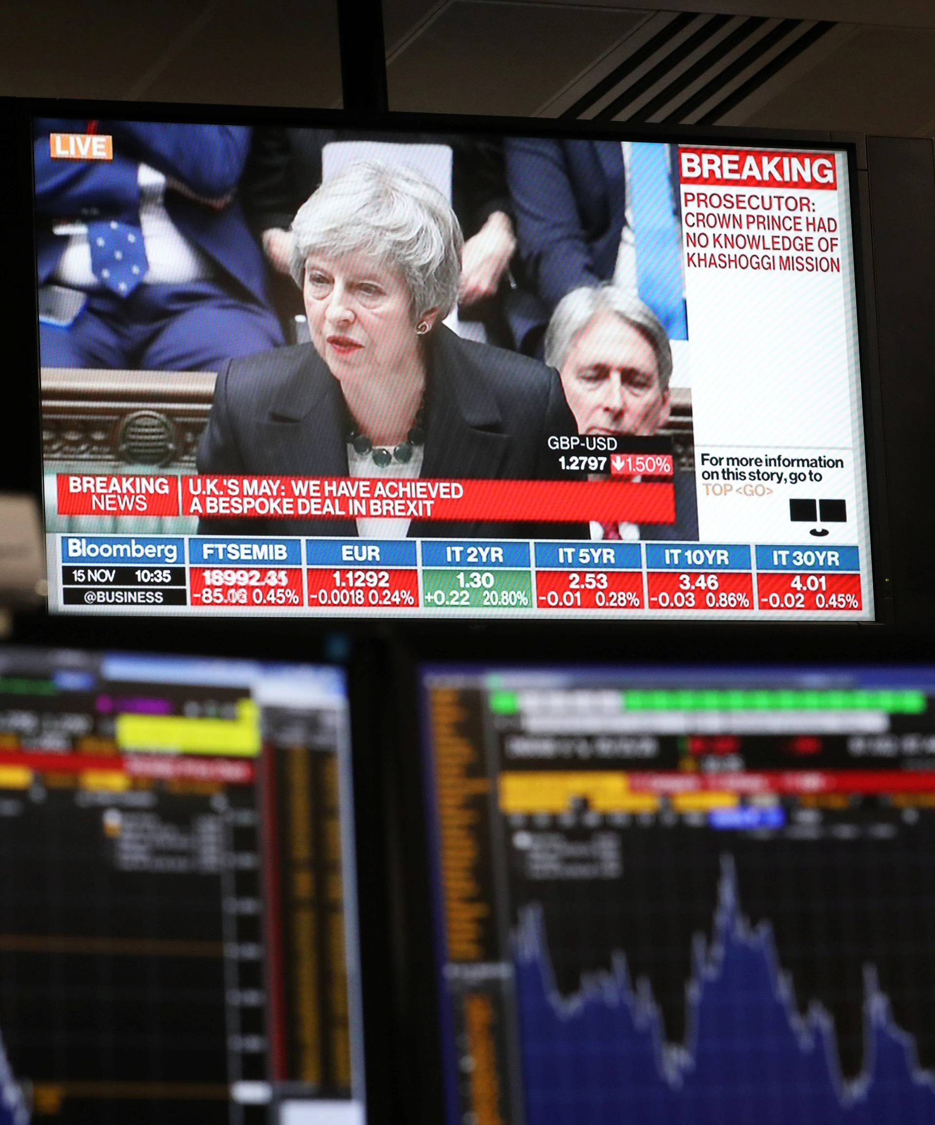 An investment manager's desk, in the office of Aberdeen Standard Investments, is seen below a televison showing Britain's Prime Minister, Theresa May, delivering a statement to the House of Commons, in London
