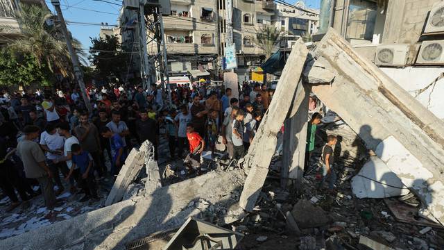 Palestinians react, after an Israeli air strike on a UN school sheltering displaced people, amid the Israel-Hamas conflict, in Nusairat