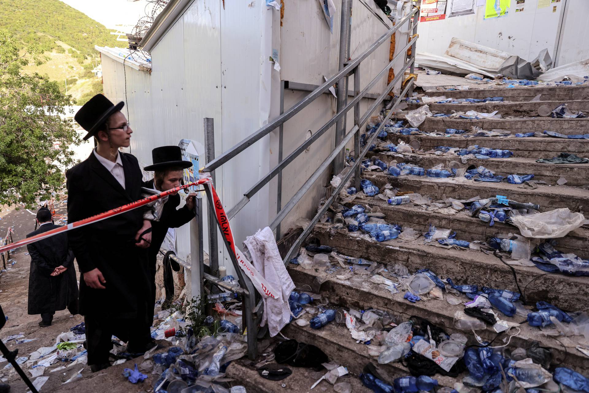 Ultra Orthodox Jews look at stairs with waste on it in Mount Meron