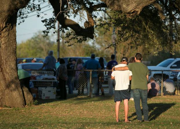 Men comfort each other at a community center after a mass shooting at the First Baptist Church in Sutherland Springs