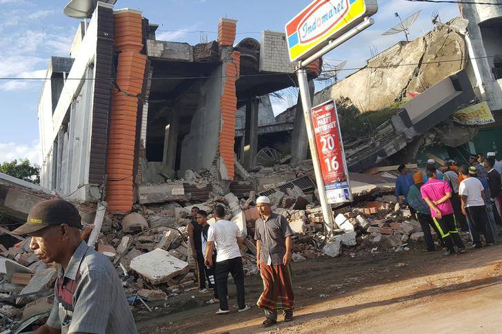 People survey the damage after dozens of buildings collapsed following a 6.4 magnitude earthquake in Ule Glee, Pidie Jaya in the northern province of Aceh, Indonesia