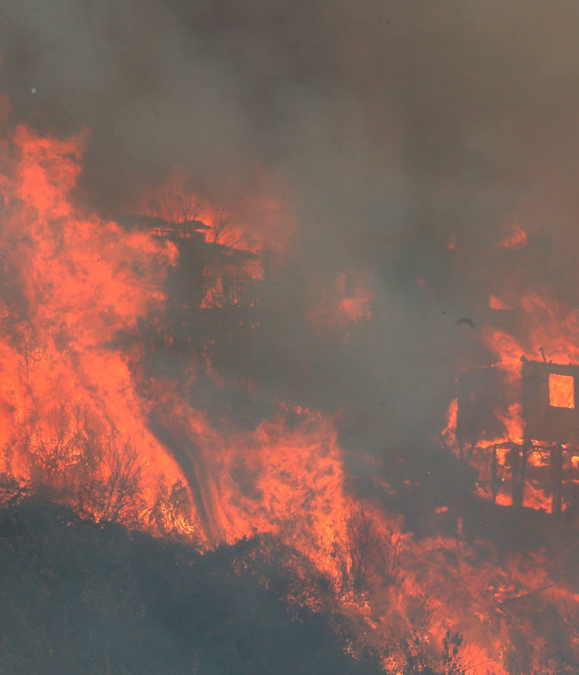 Fire burns a house on a hill, where more than 100 homes were burned due to forest fire but there have been no reports of death, local authorities said in Valparaiso, Chile