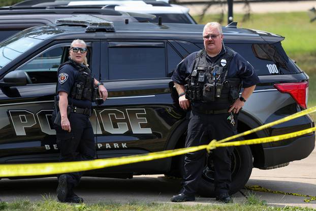 Police officers stand watch outside the home of Trump shooting suspect Thomas Crooks