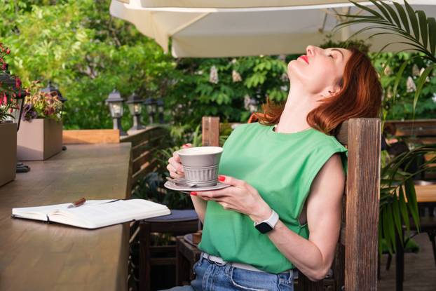 Woman leaned back in the wooden chair. Enjoy your morning cup of coffee