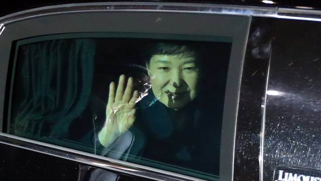 South Korea's ousted leader Park Geun-hye sitting inside a vehicle waves to her supporters upon her arrival to her private house in Seoul