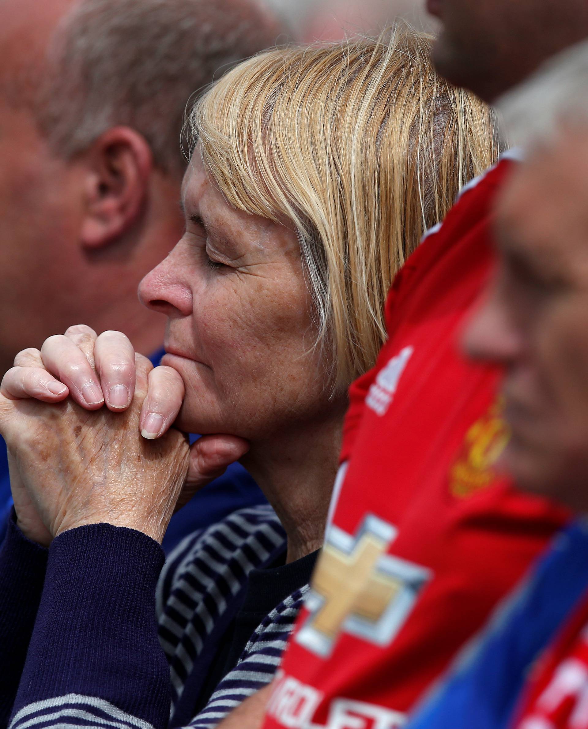 A woman reacts as football fans and wellwishers gather ahead of the funeral of Bradley Lowery