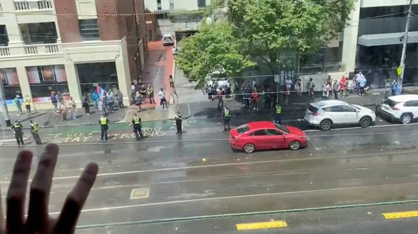 Djokovic supporters stand outside Park Hotel in Melbourne