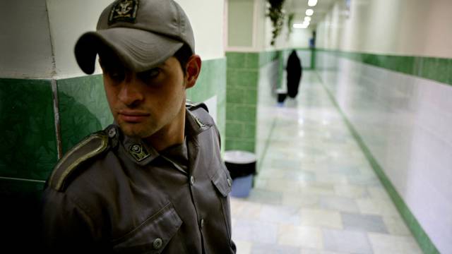 FILE PHOTO: A prison guard stands along a corridor in Tehran's Evin prison June 13, 2006. Iranian police detaine..