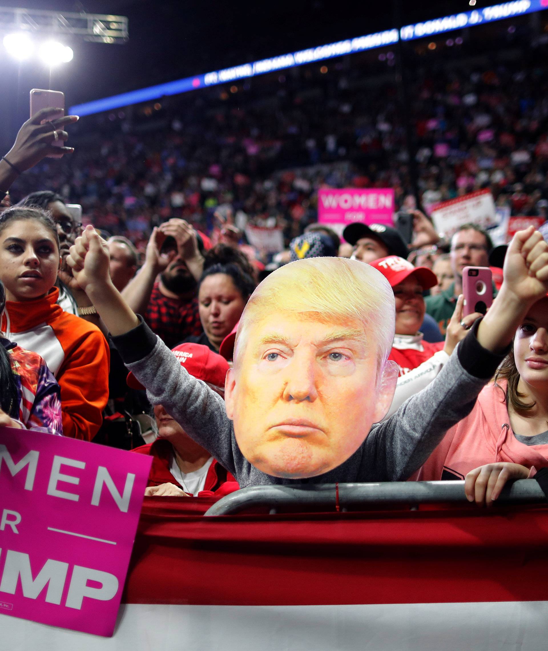 Supporters participate behind an image of U.S. President Donald Trump at a campaign rally at the Allen County War Memorial Coliseum in Fort Wayne