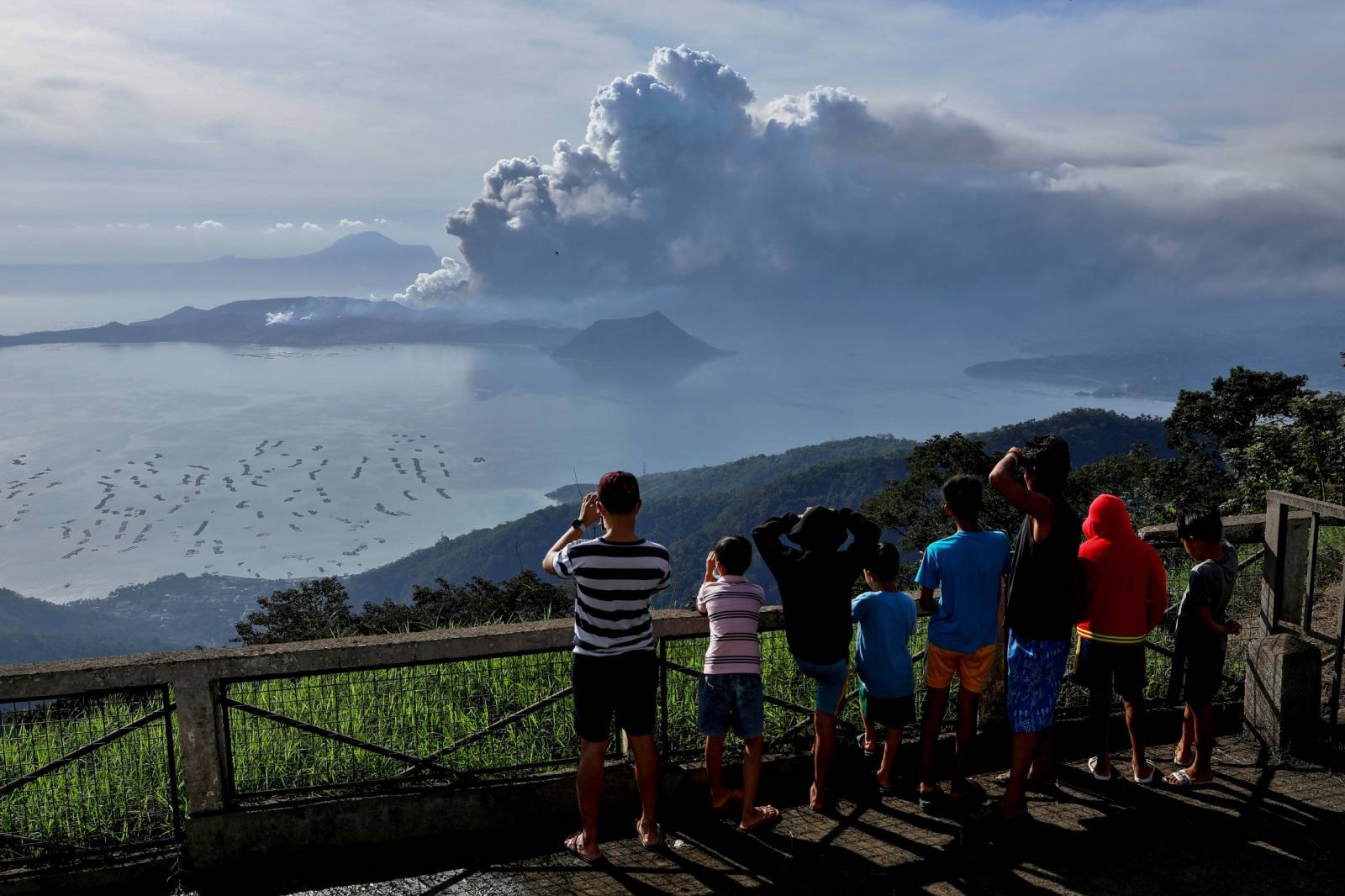 Residents look at the errupting Taal Volcano in Tagaytay City