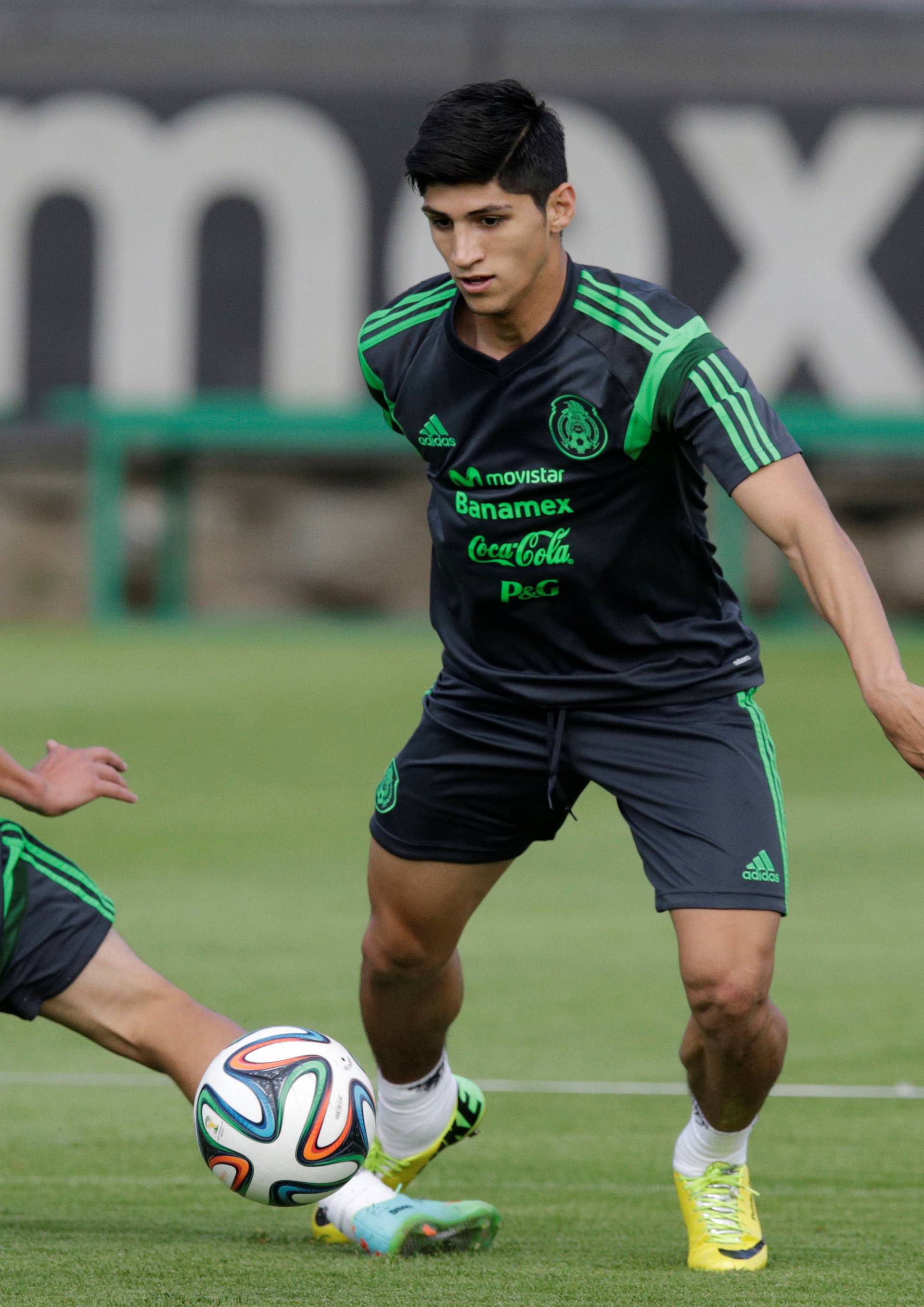 Mexico striker Pulido dribbles the ball past Aguilar during a practice session in Mexico City