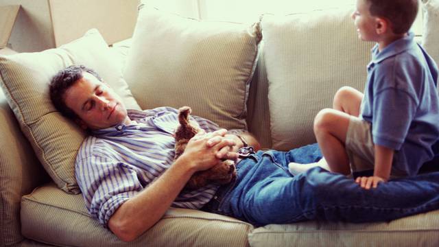 father asleep on sofa with son