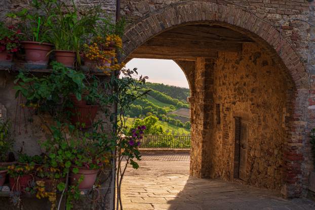 Castiglione d'Orcia medieval village, historical stone arch, ancient building, old door architecture. Orcia Valley, Tuscany, Italy.