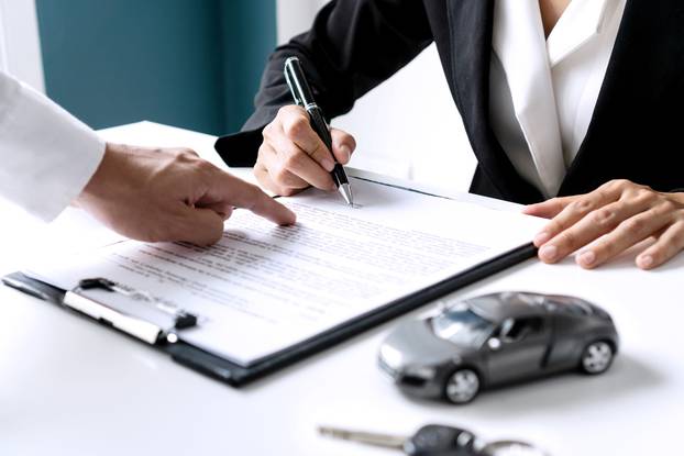 Closeup,Of,Asian,Female,Signing,Car,Insurance,Document,Or,Lease