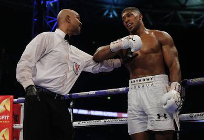Anthony Joshua is spoken to by the referee