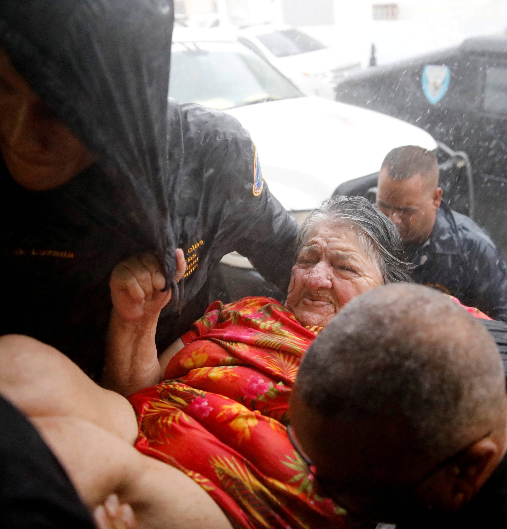 Rescue workers carry a woman into the Emergency Operation Centre after the the area was hit by Hurricane Maria in Guayama