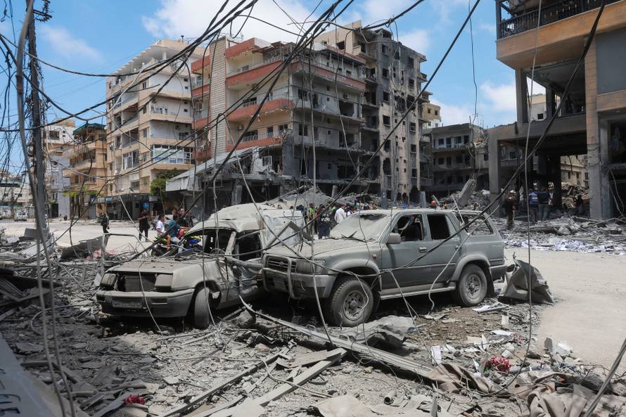 People inspect the damage in the aftermath of an Israeli strike, in Tyre