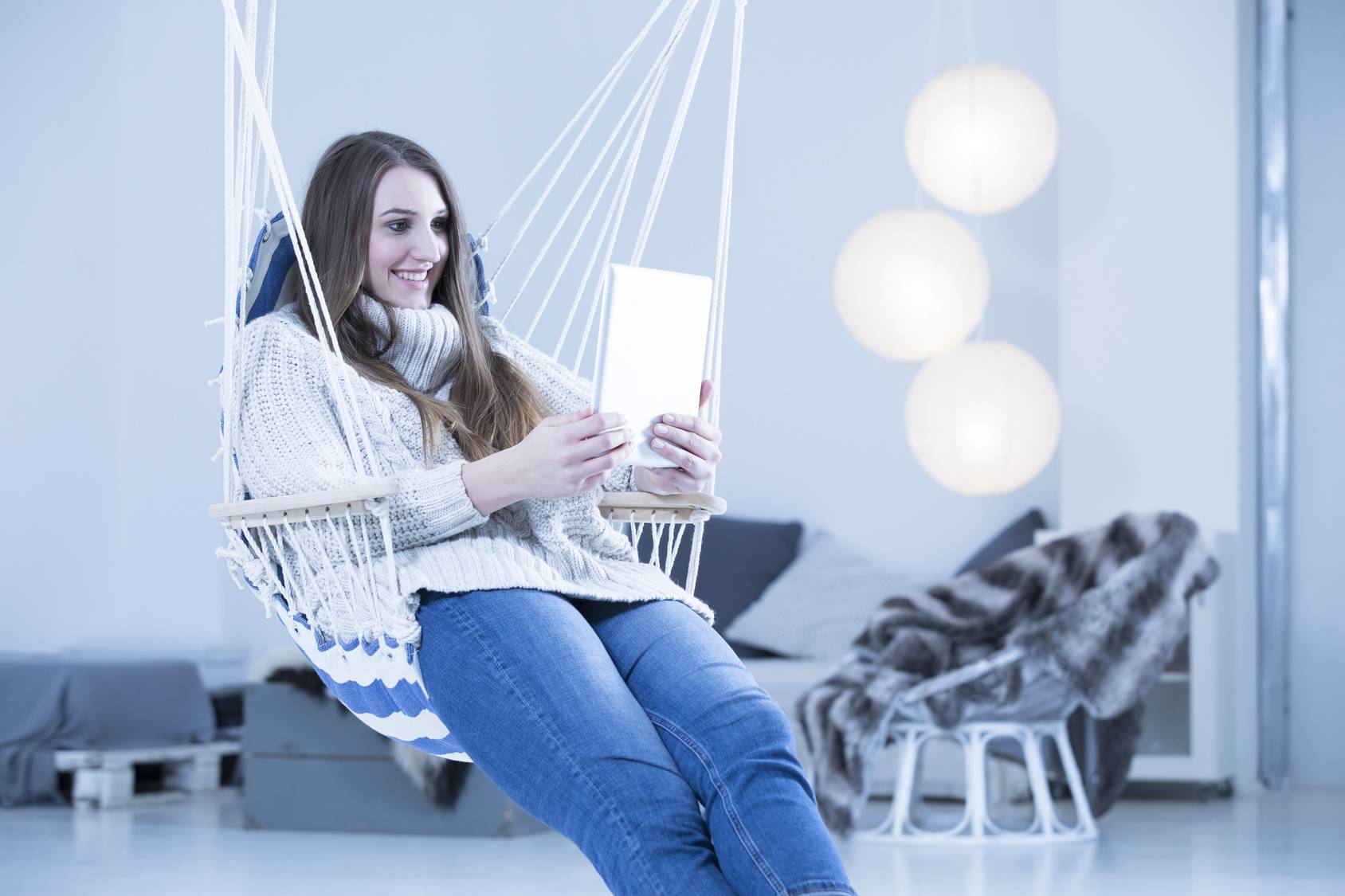 Young woman siting at home, using digital tablet