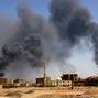 FILE PHOTO: Man walks while smoke rises above buildings after aerial bombardment in Khartoum North