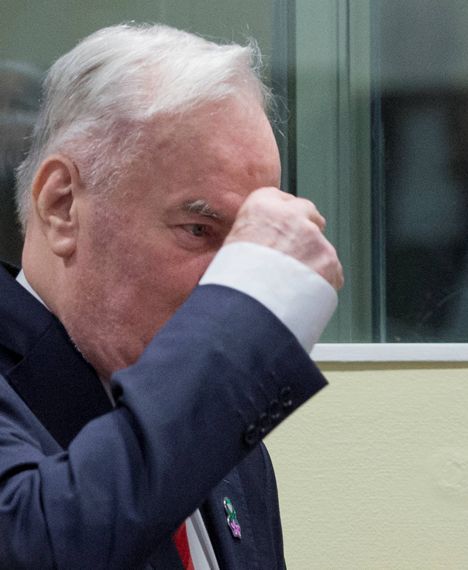 Ex-Bosnian Serb wartime general Ratko Mladic makes the sign of the cross while appearing in court at the International Criminal Tribunal for the former Yugoslavia in the Hague