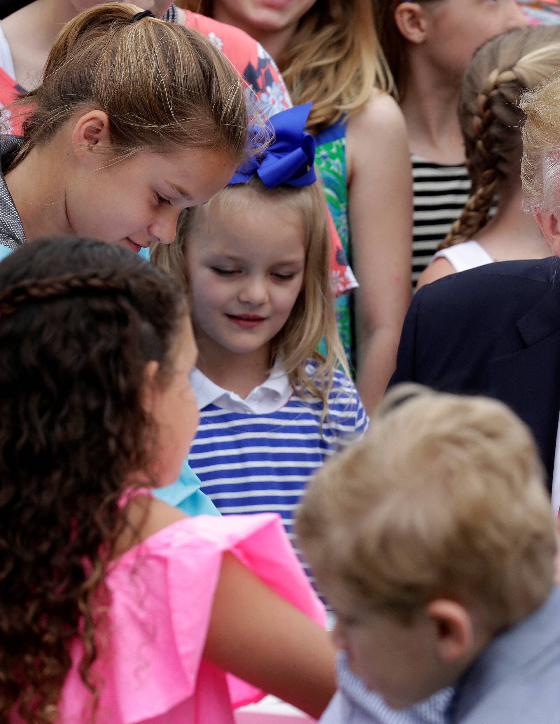 U.S. President Donald Trump speaks with children as they make Easter greeting cards for members of the military at the 139th annual White House Easter Egg Roll on the South Lawn of the White House in Washington