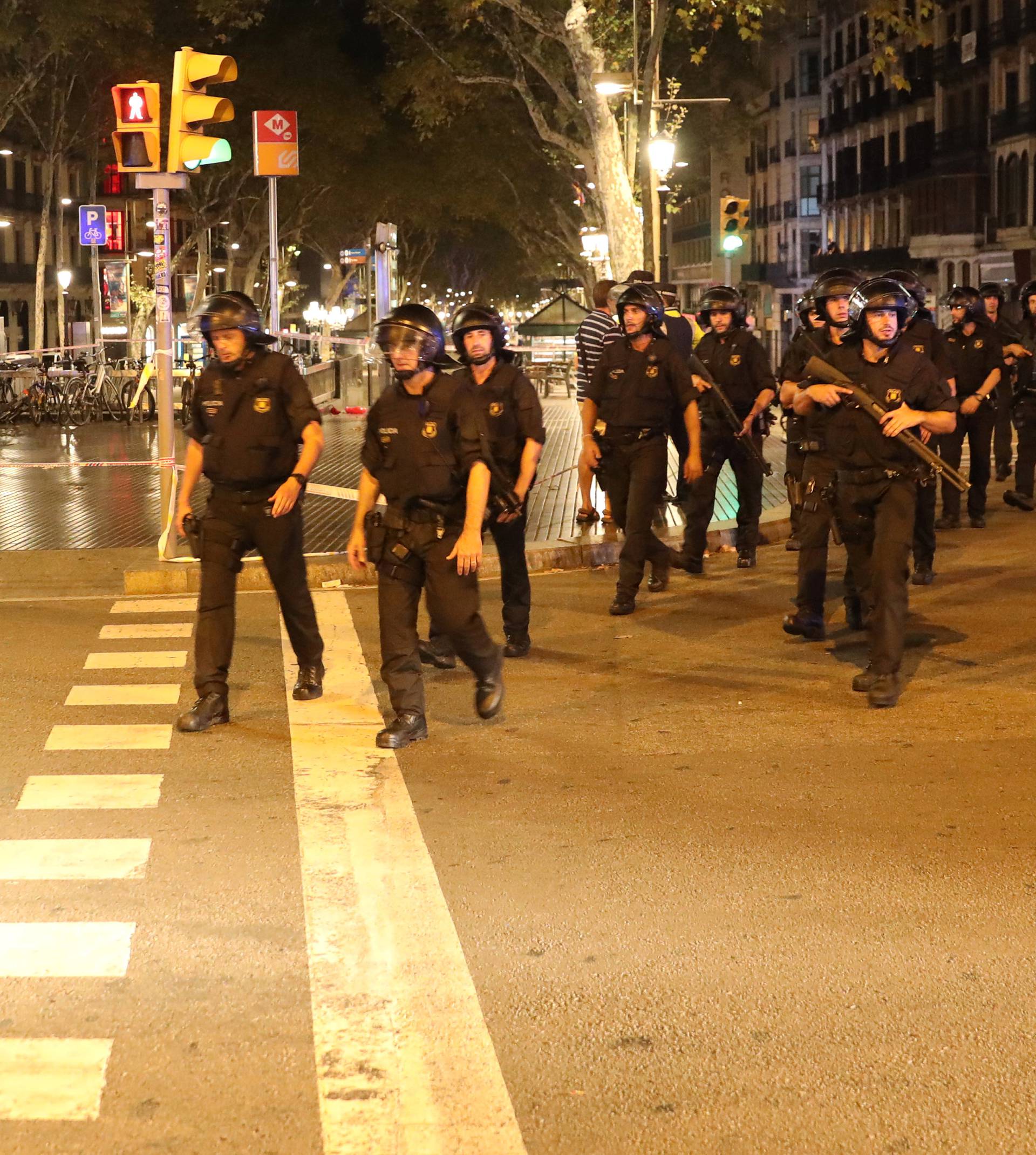 Armed Catalonian Mosses de Escuadra officers leave the area where a van crashed into pedestrians at Las Ramblas in Barcelona