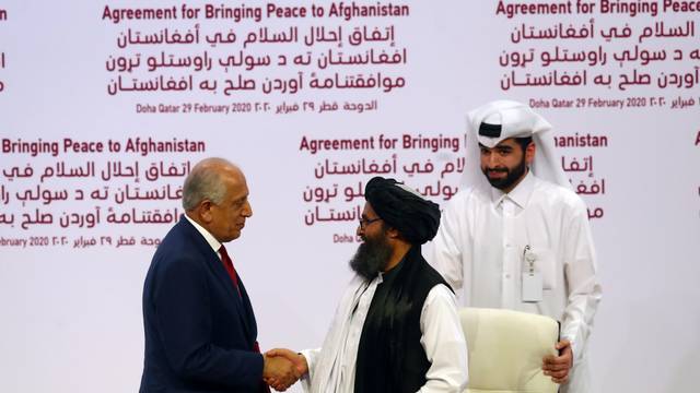 Mullah Abdul Ghani Baradar, the leader of the Taliban delegation, and Zalmay Khalilzad, U.S. envoy for peace in Afghanistan, shake hands after signing agreement at ceremony between members of Afghanistan's Taliban and the U.S. in Doha