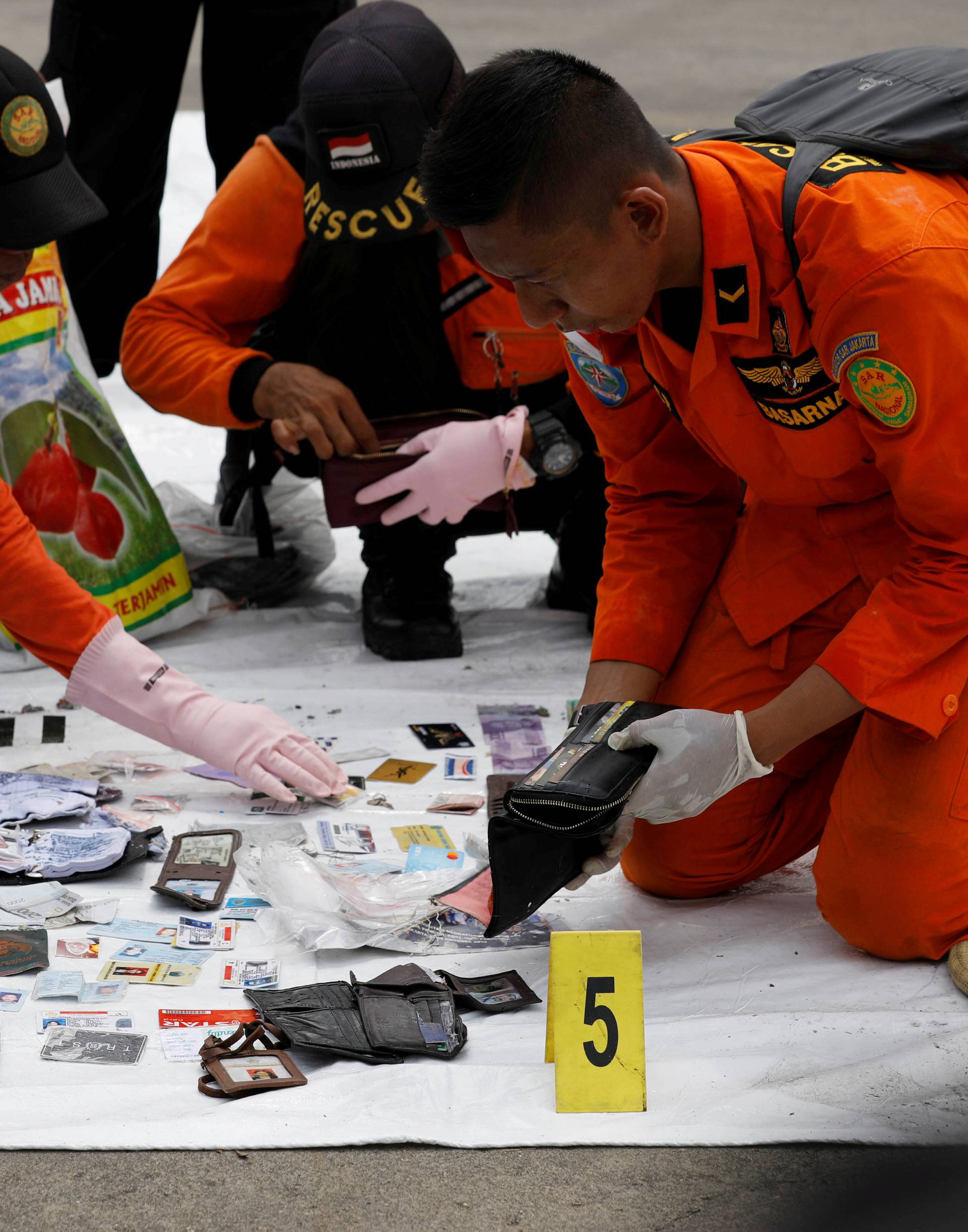 Rescue workers lay out recovered belongings believed to be from the crashed Lion Air flight JT610 at Tanjung Priok port in Jakarta