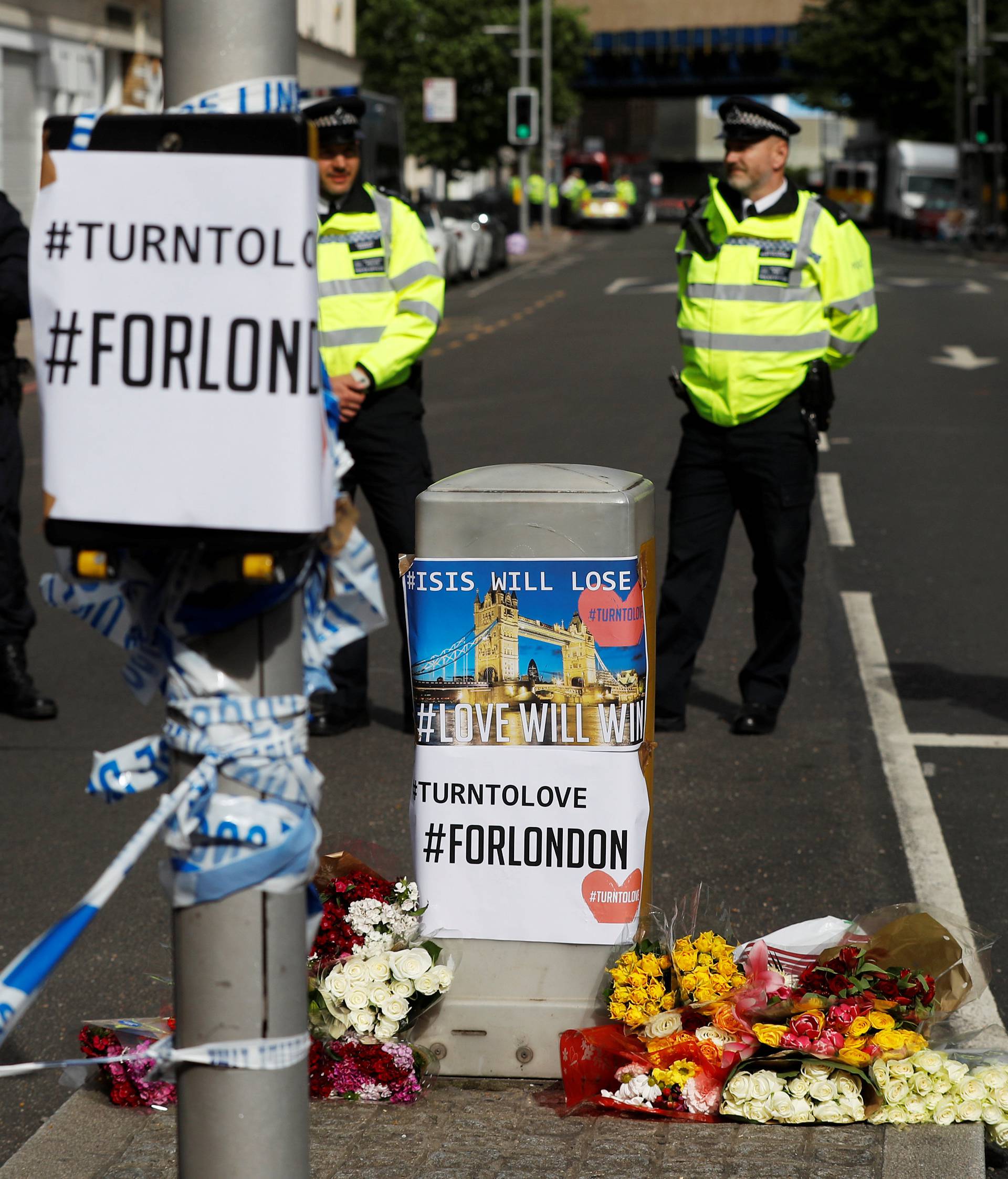 Flowers and messages lie behind police cordon tape near Borough Market after an attack left 7 people dead and dozens injured in London