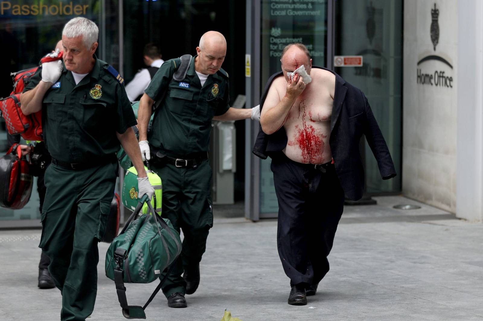 An injured man is helped by a medic outside the Home Office in London