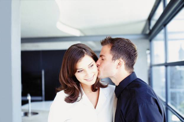 Man and woman kissing in office