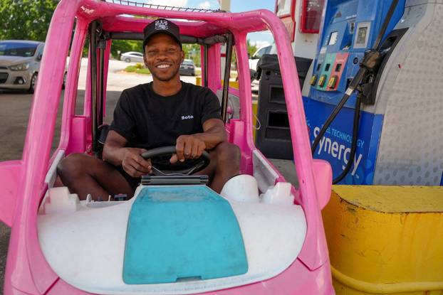 Mali Hightower poses with a pink Power Wheels Barbie Dream Camper outside a gas station in Ellenwood
