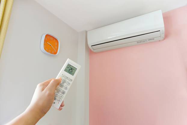 Hand turning on home air conditioning