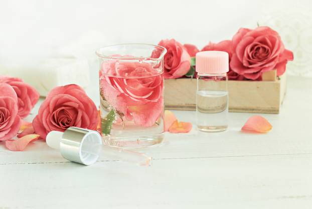Homemade rose facial tonic. Glass jar of flower attar, bottle, pippette.