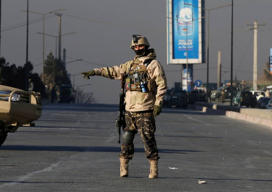 An Afghan security force personnel keeps watch close to the entrance gate of Kabul's Intercontinental Hotel during an attack by gunmen in Kabul