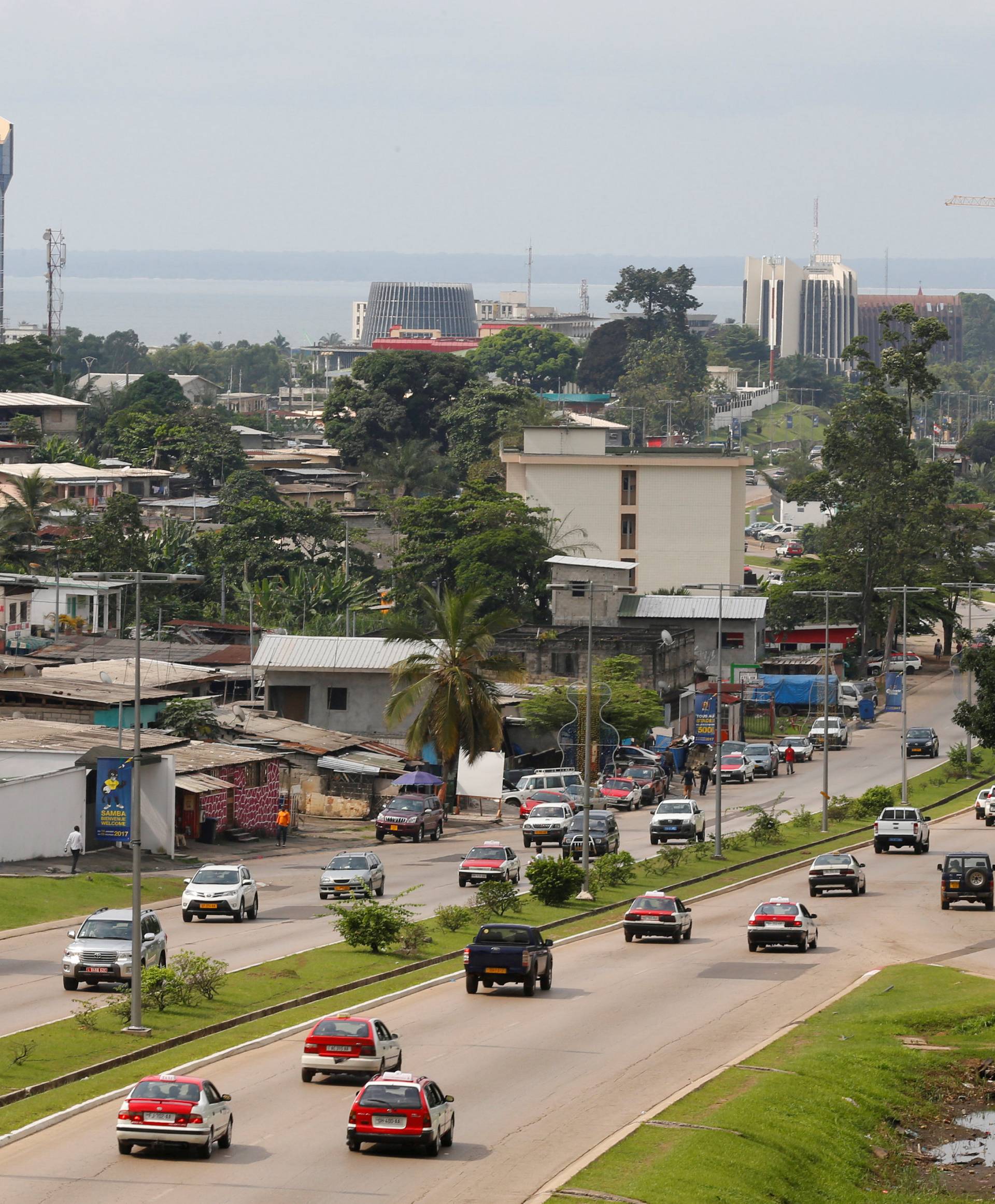 FILE PHOTO: Cars drive down a highway beneath the skyline of Libreville, Gabon's capital