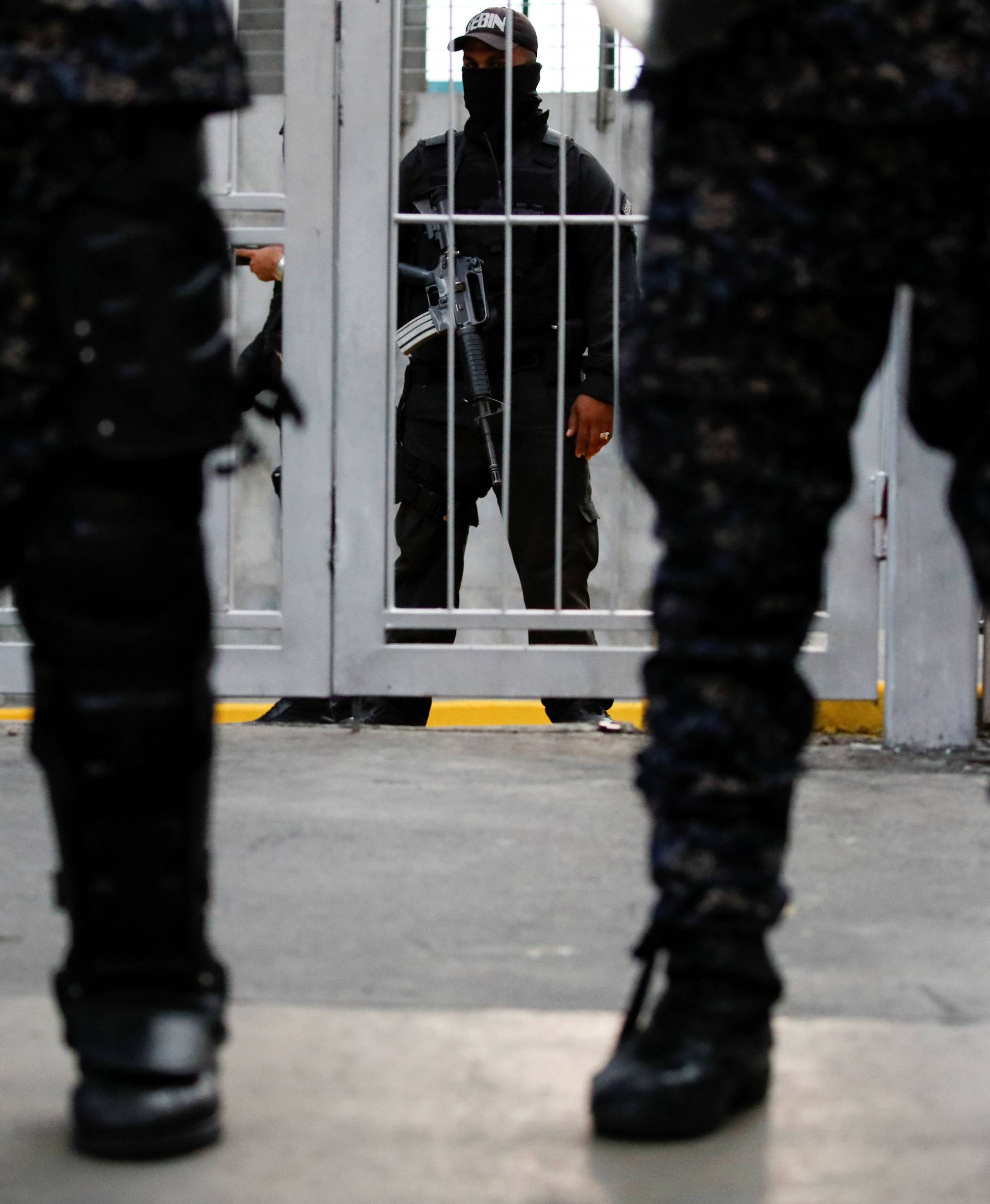 Members of Bolivarian National Intelligence Service (SEBIN) stand guard as mourners of the municipal lawmaker Fernando Alban gather outside its headquarters in Caracas