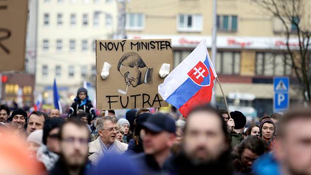 People hold up a cartoon of the new Slovak PM Pellegrini during a march in reaction to the murder of Slovak investigative reporter Jan Kuciak and his fiancee Martina Kusnirova, in Bratislava