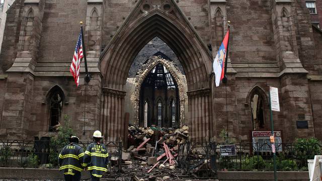 New York City firefighters (FDNY) walk through the debris following a fire at Manhattan's historic Serbian Orthodox Cathedral of Saint Sava in New York 