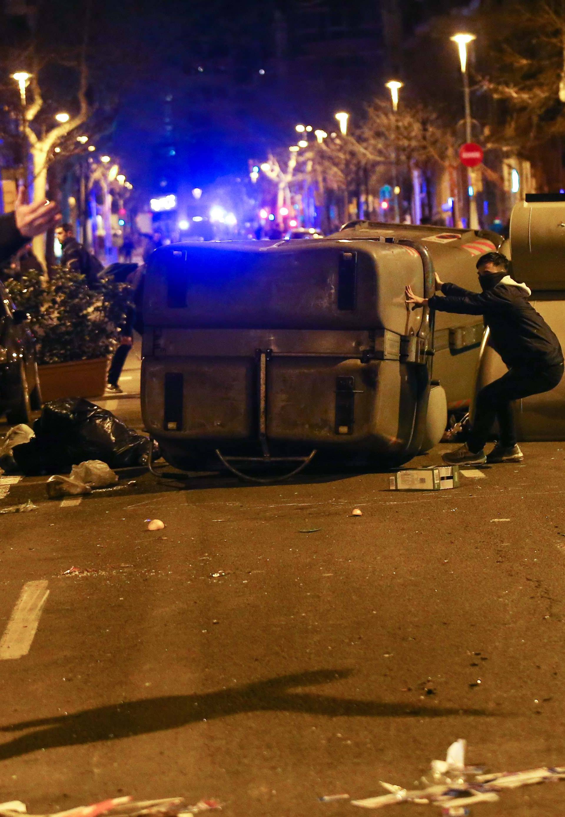 Protestors erect barricades on a street during skirmishes with police after former regional president Carles Puigdemont was detained in Germany,  in Barcelona